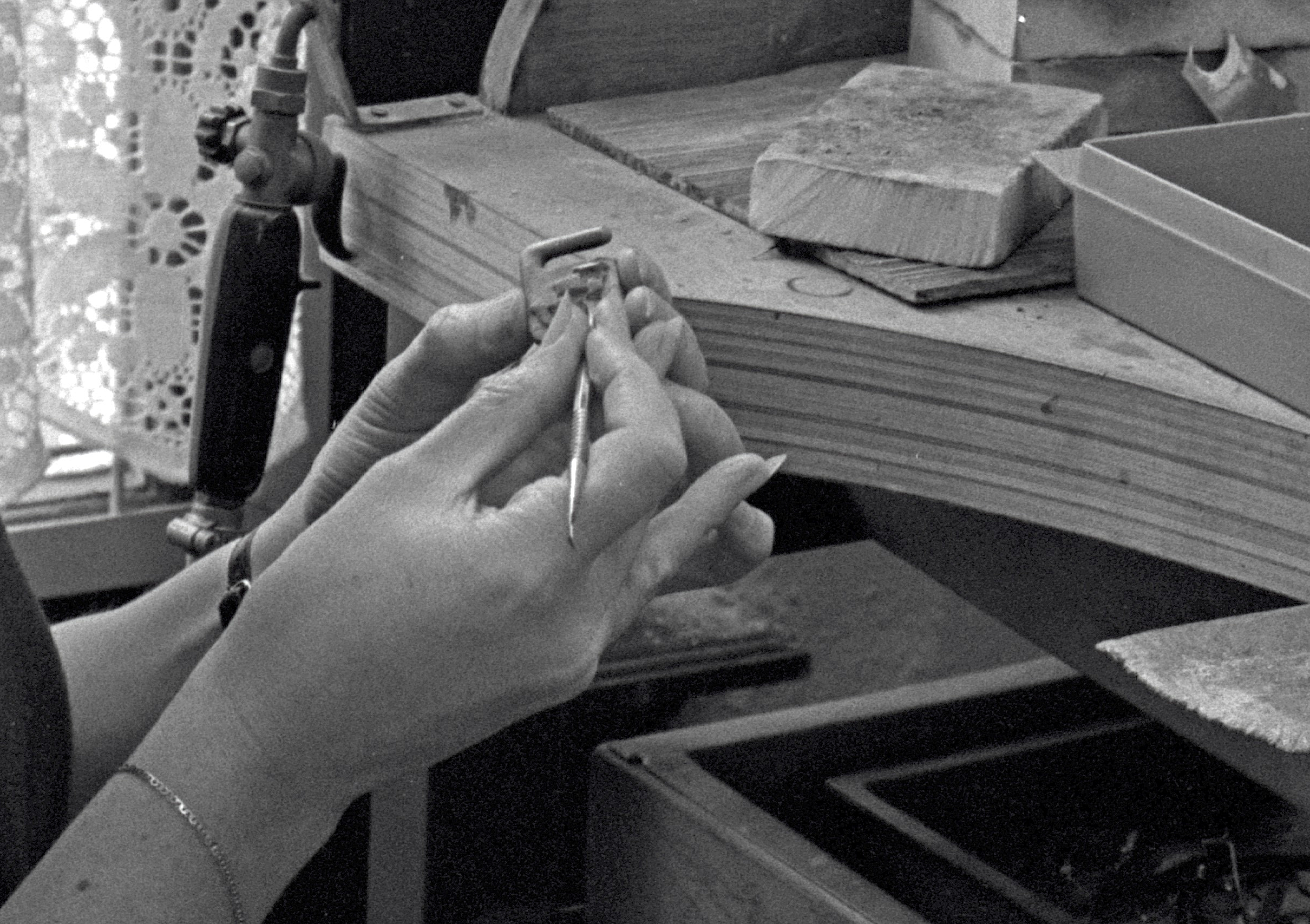 zwart-wit foto van de handen van edelsmid Dorien van Loggem tijdens het vervaardigen van de ambtsketen in 1980
