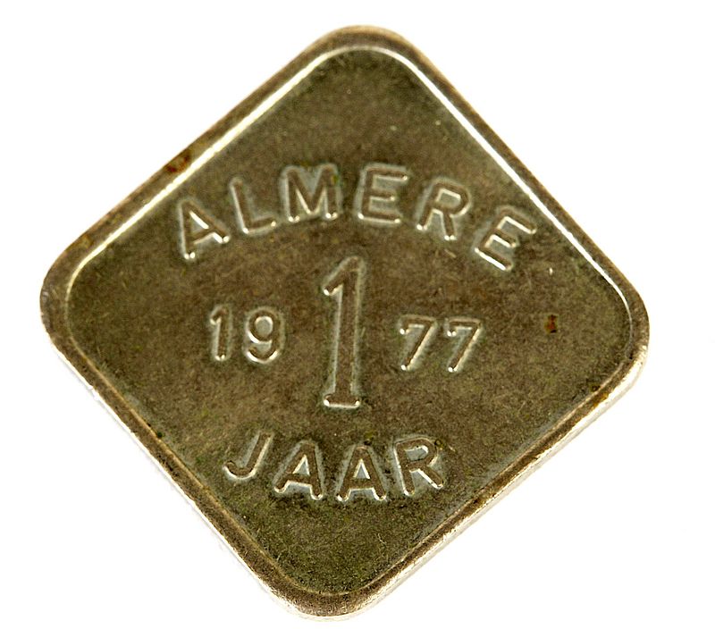 Kleurenfoto van een herdenkingsmuntje met de tekst 1 jaar Almere en het jaartal 1977